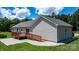 Back exterior view of a one story home with a spacious deck overlooking a well maintained yard at 125 Carter Ln, Statesville, NC 28625