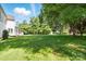 Expansive backyard with lush lawn, mature trees, screened porch and beautiful landscaping at 1295 Patterson St, China Grove, NC 28023
