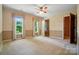 A bright bedroom featuring a ceiling fan and two windows offering views of the surrounding greenery at 1295 Patterson St, China Grove, NC 28023