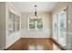 Dining room features wood floors, paneling, a modern chandelier and french doors at 1295 Patterson St, China Grove, NC 28023
