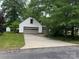 Two car garage and driveway surrounded by grass and mature trees at 1295 Patterson St, China Grove, NC 28023
