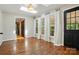 Living room with wood floors, black door, skylight, and views to landscaped yard at 1295 Patterson St, China Grove, NC 28023