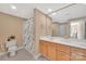 Well-lit bathroom featuring a double vanity with wood cabinets and a shower with shower curtain at 1315 East Blvd # 410, Charlotte, NC 28203
