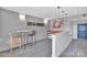 Well-lit lounge area with modern bar stools, a small kitchenette, artwork on walls, and gray carpet at 1315 East Blvd # 410, Charlotte, NC 28203