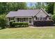 Charming single-story home with a well-manicured lawn and inviting front porch framed by lush greenery at 1318 Candlewood Dr, Gastonia, NC 28052