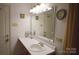 Bright bathroom featuring a single vanity, a large mirror, and white walls, creating a clean and simple look at 1332 Waterlily Ln, Charlotte, NC 28262