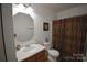 Cozy bathroom featuring a single vanity and toilet, all complemented by a framed mirror and warm, inviting lighting at 1332 Waterlily Ln, Charlotte, NC 28262