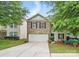 Charming two-story home with a well-manicured lawn and attached two-car garage at 1332 Waterlily Ln, Charlotte, NC 28262