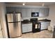 Well-lit kitchen with stainless steel refrigerator, gas stove, and light blue cabinets at 1332 Waterlily Ln, Charlotte, NC 28262