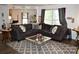 Comfortable living room with a sectional sofa, hardwood floors, and abundant natural light at 1332 Waterlily Ln, Charlotte, NC 28262