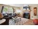 Cozy living room features a comfortable gray sofa, fireplace, and large windows at 1332 Waterlily Ln, Charlotte, NC 28262