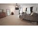 Large main bedroom with a ceiling fan, TV, and windows with dark curtains at 1332 Waterlily Ln, Charlotte, NC 28262