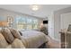 Bright bedroom featuring a wide window with natural light, complemented by striped bedding and a cozy armchair at 136 Preston Rd, Mooresville, NC 28117