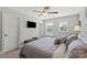 Comfortable bedroom with a large bed, a ceiling fan, and natural light streaming through the windows at 136 Preston Rd, Mooresville, NC 28117