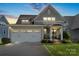 Charming two-story home with a two-car garage and well-manicured lawn at twilight at 136 Preston Rd, Mooresville, NC 28117