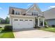 Charming two-story home with a two-car garage, well-manicured lawn, and lake view at 136 Preston Rd, Mooresville, NC 28117