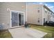 Back exterior of a home features a sliding glass door leading to a concrete patio and yard at 13612 Singleleaf Ln, Charlotte, NC 28278
