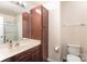 Bathroom featuring a single sink vanity with wood cabinet and drawers, accompanied by an adjacent linen storage cabinet at 13612 Singleleaf Ln, Charlotte, NC 28278