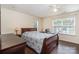 Main bedroom showcases wood-look flooring, neutral walls, ceiling fan, a double window and wood furniture at 13612 Singleleaf Ln, Charlotte, NC 28278