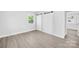 A light-filled bedroom featuring gray wood-look floors and a double closet at 1408 Delview Rd, Cherryville, NC 28021