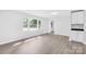 Open-concept living room with modern gray wood-look floors, built-in cabinets, and large windows at 1408 Delview Rd, Cherryville, NC 28021