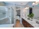 Well-lit bathroom featuring a glass-enclosed shower, double vanity, and neutral tones for a spa-like retreat at 14512 Brotherly Ln, Charlotte, NC 28278