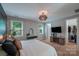 Stylish bedroom features an updated closet, mounted tv, and decorative furniture offering comfortable living at 14512 Brotherly Ln, Charlotte, NC 28278