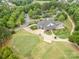 Aerial view of golf course and clubhouse with parking, mature trees, and landscaping at 14822 Rocky Top Dr, Huntersville, NC 28078