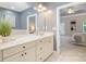 Bright bathroom with double vanity, large mirror, neutral colors and doorway into the main bedroom at 14822 Rocky Top Dr, Huntersville, NC 28078