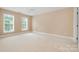 Spacious bedroom with two windows, neutral carpet, and a ceiling fan offering ample natural light at 14822 Rocky Top Dr, Huntersville, NC 28078