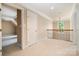 Upstairs hallway leading to various rooms, featuring a large window for natural light and white carpet at 14822 Rocky Top Dr, Huntersville, NC 28078