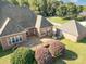 Aerial view of brick home showing large deck and detached brick garage with trees in the background at 150 Northchase Dr, Concord, NC 28027