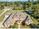 Aerial view of a stately brick home featuring a manicured lawn and mature trees on a sunny day at 150 Northchase Dr, Concord, NC 28027