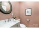 Powder room featuring a decorative mirror, marble countertops, and updated fixtures at 150 Northchase Dr, Concord, NC 28027
