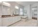 Bathroom features double vanity sinks, custom cabinetry, and a separate tub with mosaic tile accents at 15927 Vale Ridge Dr, Charlotte, NC 28278