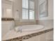 Bathtub with mosaic tile accents, window with shutters, and faucet with silver finish at 15927 Vale Ridge Dr, Charlotte, NC 28278