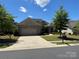 Beautiful brick home with a two-car garage, manicured lawn, and lovely landscaping at 15927 Vale Ridge Dr, Charlotte, NC 28278