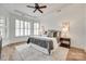 Bedroom with tray ceiling, ceiling fan, hardwood floors and bright, shuttered windows at 15927 Vale Ridge Dr, Charlotte, NC 28278