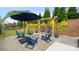 Landscaped backyard featuring a fire pit with Adirondack chairs and swinging egg chairs under an umbrella at 1620 Callahan Rd, Fort Mill, SC 29715