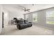 Bright living room featuring plush carpeting, a modern ceiling fan, and large windows at 1620 Callahan Rd, Fort Mill, SC 29715