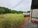 Landscaped backyard with a deck, lawn and scattered trees for a peaceful outdoor setting at 181 Trivette Rd, Harmony, NC 28634