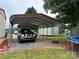View of the carport with gravel driveway, supporting multiple vehicles in a landscaped yard at 181 Trivette Rd, Harmony, NC 28634