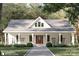Charming home featuring board and batten siding, a welcoming front porch, and inviting rocking chairs at 1821 Country Club Rd, Wadesboro, NC 28170