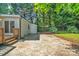 View of home's back exterior, featuring an additional storage unit and treelined backyard at 1829 Jennings St, Charlotte, NC 28216