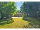 View of home's backyard and back exterior from the yard, featuring treelined privacy at 1829 Jennings St, Charlotte, NC 28216
