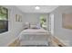 Bright, neutral bedroom featuring a ceiling fan, large bed, and two windows at 1829 Jennings St, Charlotte, NC 28216