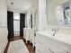 Bright bathroom featuring double vanities, cabinet with mirrors, and neutral rug on dark hardwood floor at 1915 Winthrop Ave, Charlotte, NC 28203