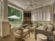 Inviting covered patio with stone fireplace, ceiling fan, and comfortable seating area at 1915 Winthrop Ave, Charlotte, NC 28203