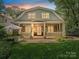 Charming home with a large porch and an outdoor cooking area at dusk at 1915 Winthrop Ave, Charlotte, NC 28203