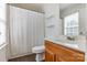 Bright bathroom featuring a wooden vanity, shower with curtain, and light-filled window at 197 Devon Forest Dr, Mooresville, NC 28115